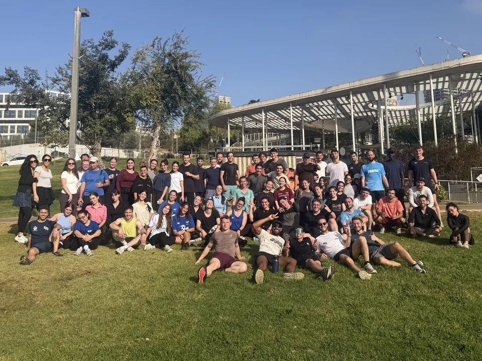 Run Club Jeru runners gathered on the grass in Gan Sacher Park after a run.